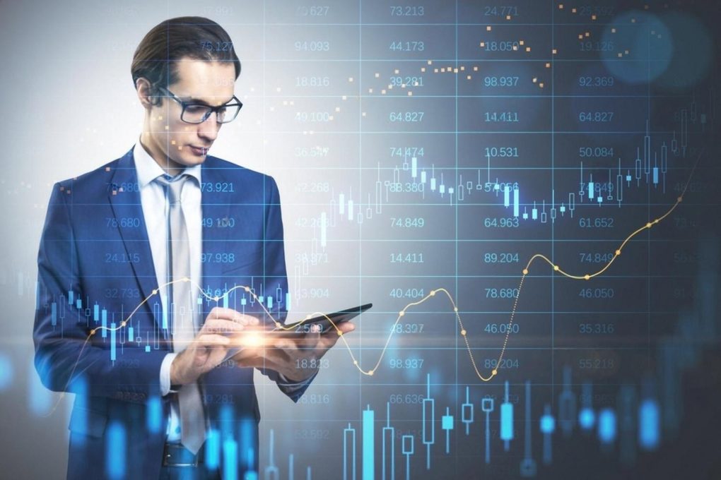 Young finance professional reviewing charts and market data on a tablet