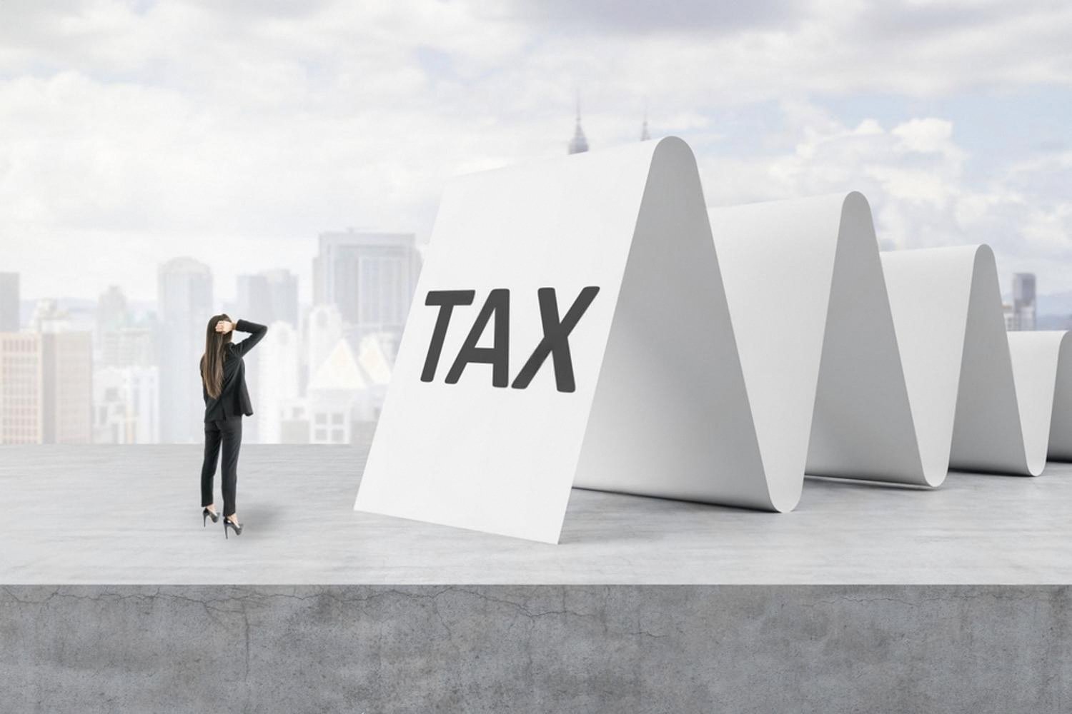 Accountant standing near a large TAX sign representing UAE tax and compliance work